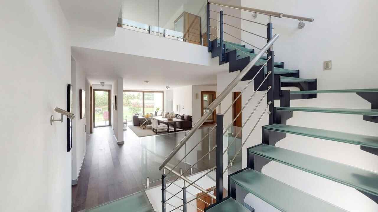 Interiérové schodište se skleněnými stupni a zábralím z nerezu, konstrukce vbervě antracit